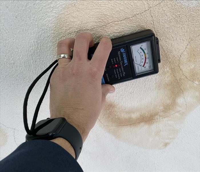 Using a moisture meter at a Medford residence. 